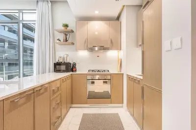 a kitchen with wooden cabinets and a stove top oven at Modern Family Home with Dubai Skyline Views in Dubai