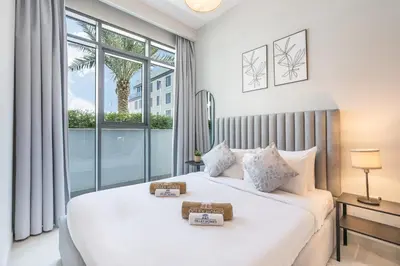 a bedroom with a large white bed with a window at Modern Family Home with Dubai Skyline Views in Dubai