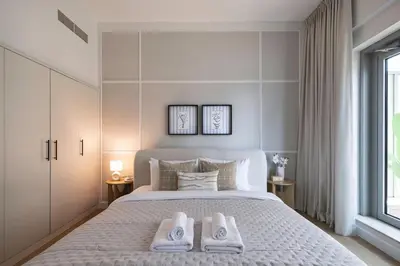 a bedroom with a large bed with two towels on it at The Fountain Views Suite in Downtown Dubai in Dubai