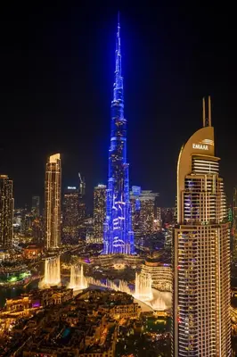 a city lit up in blue at night at Burj Khalifa View - Immersive Expérience - Downtown - DUBAI 3BR in Dubai