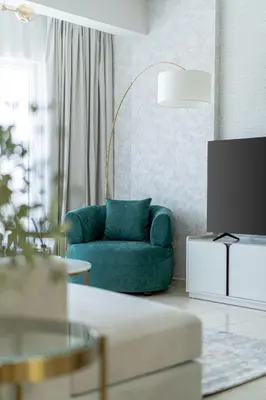 a living room with a blue couch and a table at Nasma Luxury Stays - Sky-High Serenity in Stylish 2BR Retreat in Dubai