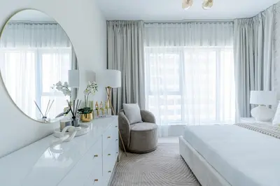 a white bedroom with a bed and a mirror at Nasma Luxury Stays - Sky-High Serenity in Stylish 2BR Retreat in Dubai