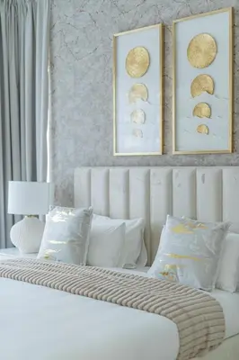 a white bed with two pictures on the wall at Nasma Luxury Stays - Sky-High Serenity in Stylish 2BR Retreat in Dubai