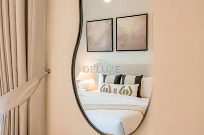 a mirror in a bedroom with a bed and framed pictures at Lagoon and Beach Access, Near Festival City Mall, Mins From Downtown Dubai, Rosewater at Creek Beach Building 2, Creek Beach by Deluxe Holiday Homes in Dubai