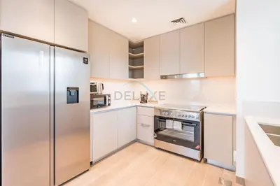 a kitchen with white cabinets and a stainless steel refrigerator at Lagoon and Beach Access, Near Festival City Mall, Mins From Downtown Dubai, Rosewater at Creek Beach Building 2, Creek Beach by Deluxe Holiday Homes in Dubai