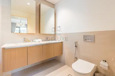 a bathroom with a toilet and a sink and a mirror at Lagoon and Beach Access, Near Festival City Mall, Mins From Downtown Dubai, Rosewater at Creek Beach Building 2, Creek Beach by Deluxe Holiday Homes in Dubai