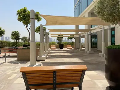 a wooden bench sitting in front of a building at Spacious Studio with full Burj Khalifa view Jaddaf in Dubai