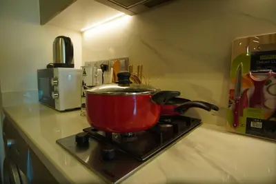a red pot on a stove in a kitchen at Spacious Studio with full Burj Khalifa view Jaddaf in Dubai