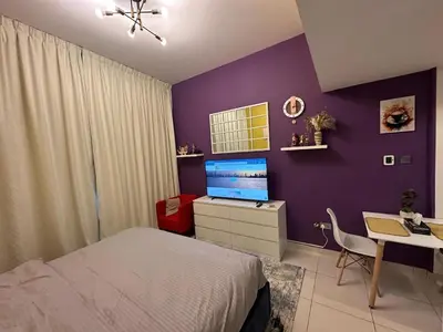 a bedroom with a purple wall with a bed and a desk at Livincci - Luxury Studio in Dubai Marina - 16 in Dubai