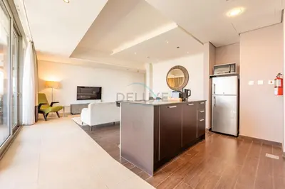 a kitchen and living room with a couch and a table at Near Dubai International Cricket Stadium, Minutes drive to Mall of the Emirates, The Matrix Tower, Sports City By Deluxe Holiday Homes in Dubai