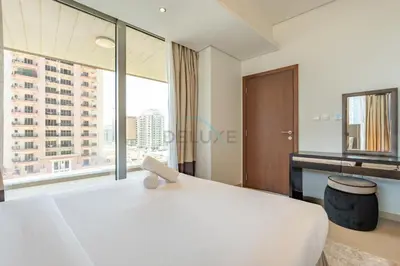 a bedroom with a white bed and a large window at Near Dubai International Cricket Stadium, Minutes drive to Mall of the Emirates, The Matrix Tower, Sports City By Deluxe Holiday Homes in Dubai