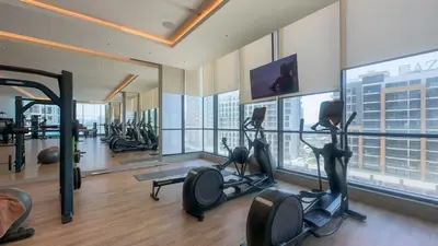 a gym with treadmills and ellipticals in a building at Spacious 2BR, Sobha Waves, Family-Friendly Stay - 3AB11 in Dubai