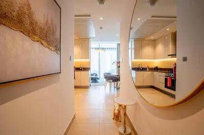 a kitchen and dining room with a mirror on the wall at Amazing Pool LUX Location 1 Bedroom Apartment in Dubai