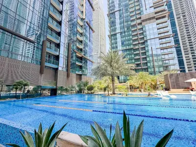 a large swimming pool in the middle of some tall buildings at Amazing Pool LUX Location 1 Bedroom Apartment in Dubai