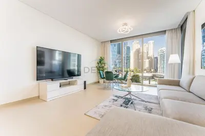 a living room with a large tv and a couch at Short walk to Marina Walk and JBR Beach, close to Bluewaters Island and Ain Dubai, 5242 Tower 1, Dubai Marina by Deluxe Holiday Homes in Dubai