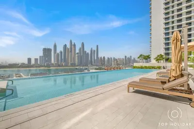 a swimming pool with chairs and a city skyline at Luxury High floor apartment Atlantis & palm view in Dubai