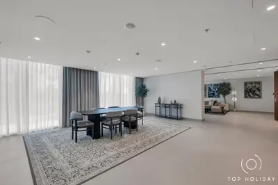 a dining room with a table and chairs on a rug at Luxury High floor apartment Atlantis & palm view in Dubai