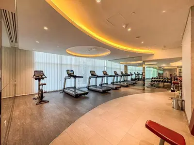 a gym with a row of treadmills and exercise bikes at Stylish 2BR - Near Burj Khalifa & City Views in Dubai