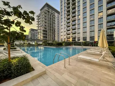 a large swimming pool in a city with tall buildings at GuestReady - Golden paradise in Dubai Hills in Dubai