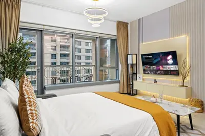 a bedroom with a large bed and a tv at White House With Burj Views, Free Parking in Dubai