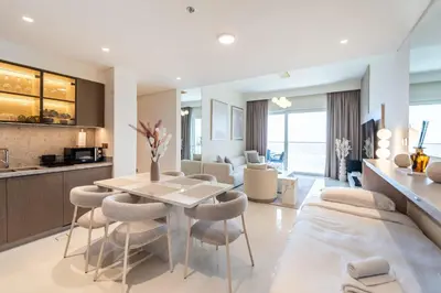 a kitchen and living room with a table and chairs at Elie Saab Tower Luxury Apartment in Dubai
