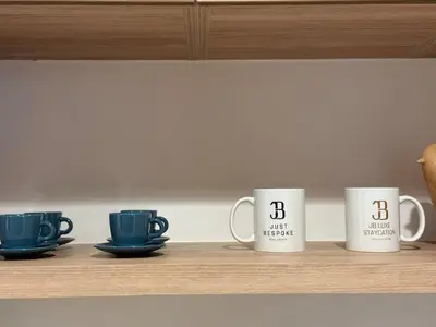 four coffee mugs are sitting on a shelf at Canal View 1BR - Business Bay - Fully Furnished in Dubai