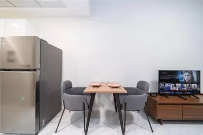 a dining room with a table and a refrigerator at Contemporary Studio Getaway in Jebel Ali in Dubai