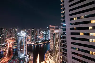 a city skyline at night with a river and buildings at Best Marina & Ain Dubai View | Steps to JBR beach in Dubai