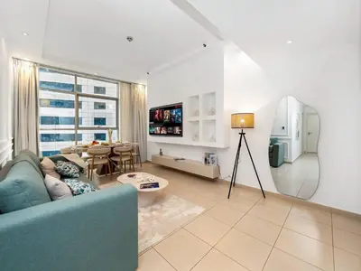 a living room with a blue couch and a table at Best Marina & Ain Dubai View | Steps to JBR beach in Dubai