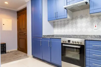a kitchen with blue cabinets and a stove at Peace Of The Soul By Lagom Jumeirah Lake Towers in Dubai