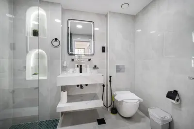 a bathroom with a sink and a toilet and a mirror at Chic 2BR Steps to JBR Beach in Dubai