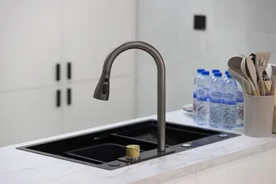 a kitchen sink with a faucet on a counter at Chic 2BR Steps to JBR Beach in Dubai