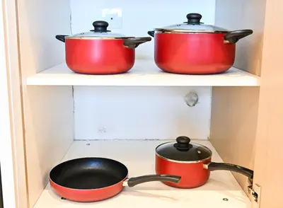 three pots and pans sitting on a stove in a kitchen at New Luxe 2BR in Burj Royale, 1 Min Walk to Dubai Mall,40th Floor, Burj Khalifa View Pool, Wifi, Gym in Dubai