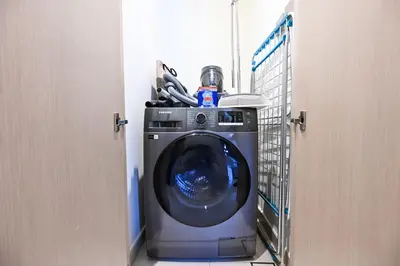 a washing machine in a room with a door open at New Luxe 2BR in Burj Royale, 1 Min Walk to Dubai Mall,40th Floor, Burj Khalifa View Pool, Wifi, Gym in Dubai