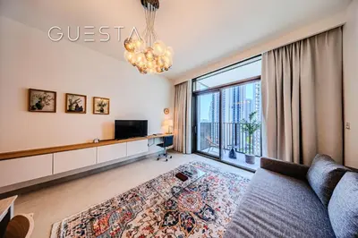 a living room with a couch and a large window at Creek Crescent by Emaar, Dubai Creek Harbour in Dubai