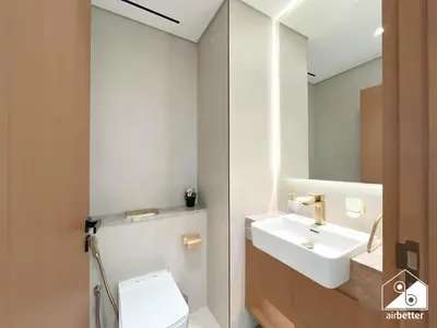 a bathroom with a sink and a toilet and a mirror at Stylish 1 Bedroom with Pool Access in JVC in Dubai