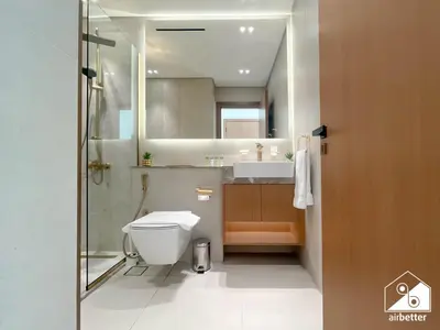 a bathroom with a toilet and a sink and a mirror at Stylish 1 Bedroom with Pool Access in JVC in Dubai