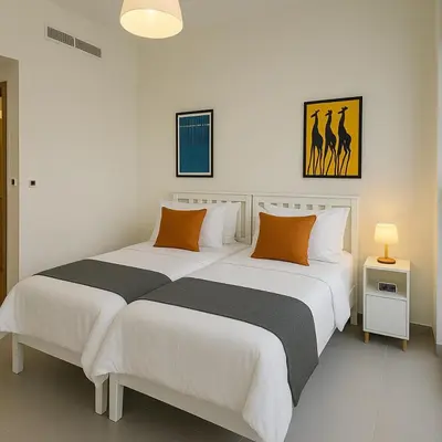 two beds in a room with white and orange pillows at The Greendoor Downtown - Burj view in Dubai