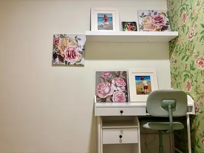 a desk with flowers on a wall with a chair at The Greendoor Downtown - Burj view in Dubai