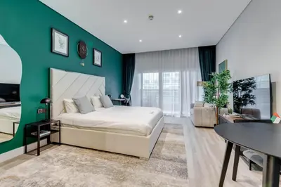 a bedroom with a bed and a green wall at Knokey Cozy Studio Apartments in Business Bay in Dubai