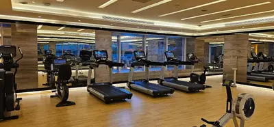 a gym with treadmills and ellipticals in a building at Knokey Cozy Studio Apartments in Business Bay in Dubai