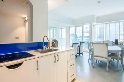 a kitchen with a sink and a table with chairs at Modern 1BR with Balcony and Marina Views in Al Majara 2 in Dubai