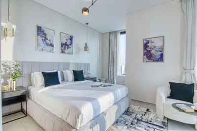 a white bedroom with a large bed and a chair at Address Beach Resort - 1BDR With Private Beach in Dubai