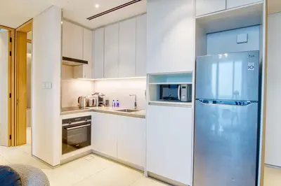 a kitchen with a refrigerator and a microwave at Address Beach Resort - 1BDR With Private Beach in Dubai