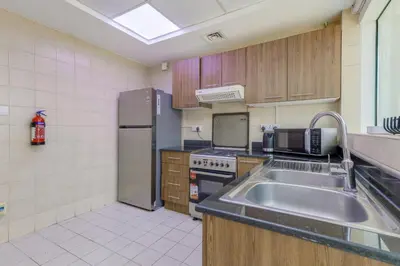 a kitchen with a sink and a refrigerator at Apartment in Downtown As Dormitory Room for male in Dubai