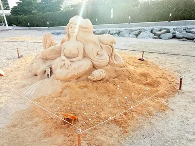 a sand sculpture of two women sitting on a beach at Oceana Residences Holiday Beach Home in Dubai