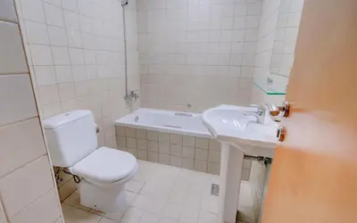 a white bathroom with a toilet and a sink at Manchester Tower Dubai Marina in Dubai