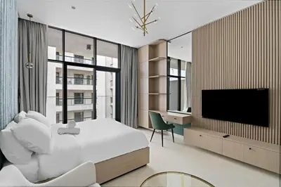 a bedroom with a bed and a tv and a desk at Modern Studio close to Marina with Balcony - 5 min walk from Metro in Dubai