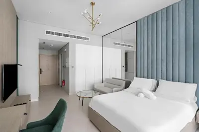 a bedroom with a bed and a couch and a tv at Modern Studio close to Marina with Balcony - 5 min walk from Metro in Dubai