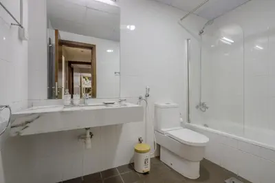 a white bathroom with a sink and a toilet at Apartment in Downtown As Dormitory Room for female in Dubai